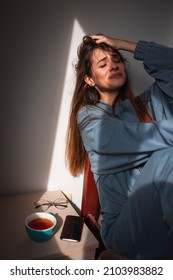 Anxious Young Woman Wearing Pajamas, Sitting On Bed In The Morning, Holding Head In Hands, Crying