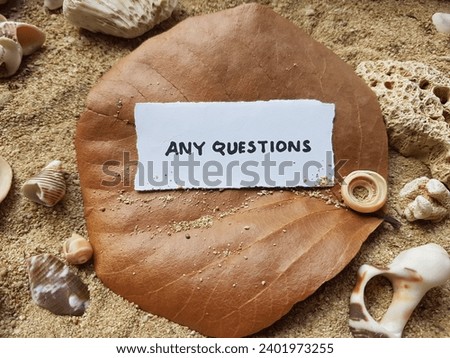 Any questions written on the beach sand background.