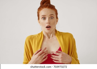 Anything buy that! Gorgeous ginger student girl with hair knot having astonished startled look, her eyes and expression full of surprise and shock as she sees something frightening in front of her