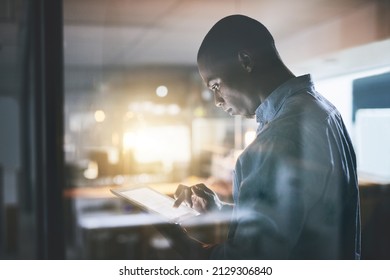 Anything is doable with dedication. Cropped shot of a handsome young businessman using a digital tablet during a late night in a modern office.
