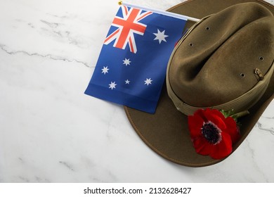 Anzac army slouch hat with Australian Flag and Poppy on stone background