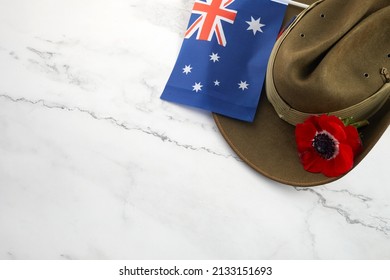 Anzac army slouch hat with Australian Flag and Poppy on stone background