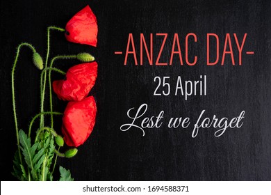 Anzac day. Greeting card with the inscription and poppy flowers on a black background. Flat lay, top view.