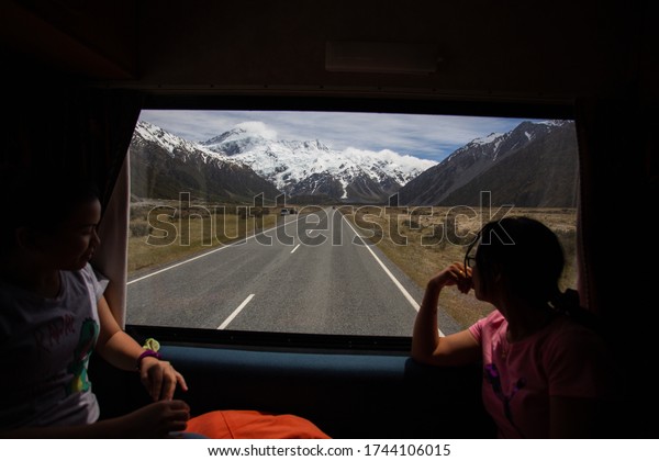 Aoraki mount cook, New  Zealand - November 12,\
2017  : Two asian tourists Looking through the window of a camper\
van, New Zealand.