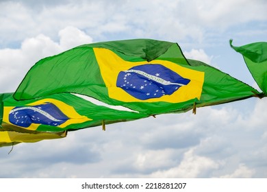 APARECIDA DE GOIANIA GOIAS BRAZIL – OCTOBER 23 2022: Some Brazilian Flags, Waving In The Wind, On Display On The Clothesline With The Cloudy Sky In The Background.