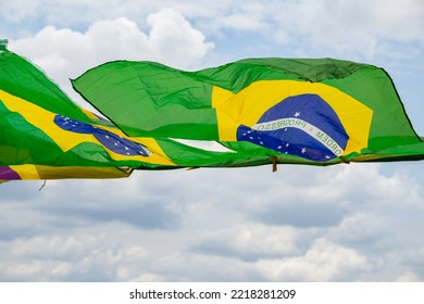 APARECIDA DE GOIANIA GOIAS BRAZIL – OCTOBER 23 2022: Some Brazilian Flags, Waving In The Wind, On Display On The Clothesline With The Cloudy Sky In The Background.