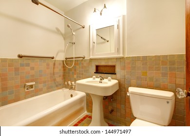 Apartment Bathroom With Old Antique Fixtures And White Tub.