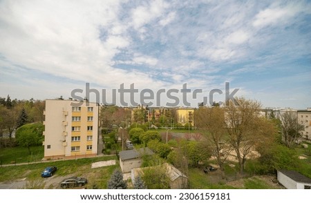 Apartment blocks from the 60s -70s of the twentieth century. A historic housing estate in Ostrowiec Swietokrzyski. Apartment blocks among the greenery under the blue sky.  