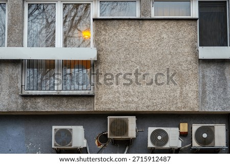 Apartment building facade with windows and external air conditioning units showing concrete multi family architecture of urban residential building
