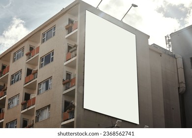 Apartment building, mockup space and advertising billboard, commercial housing and real estate in city. Empty poster for property marketing, branding and communication with announcement in urban area