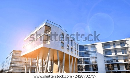 A apartment building with a unique architectural solution. A modern residential building with a white facade and standing on high concrete pillars.