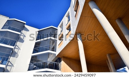 A apartment building with a unique architectural solution. A modern residential building with a white facade and standing on high concrete pillars.