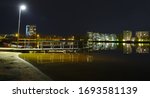 Apartment buildings between Kasarmintie and Salmelantie and the pier of Tuira beach reflecting from the surface of Oulu river.