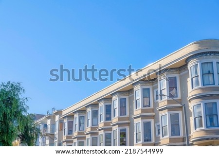 Apartment buildings with decorative frieze and dentils in San Francisco, California. Apartment building exterior with curved walls on the right side and bay windows at the front.