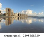 Apartment Buildings are mirroring at the Beach of Candeias and Piedade, Jaboatao dos Guararapes, Pernambuco, Brazil just after sunrise. The City of Recife is to see in the background