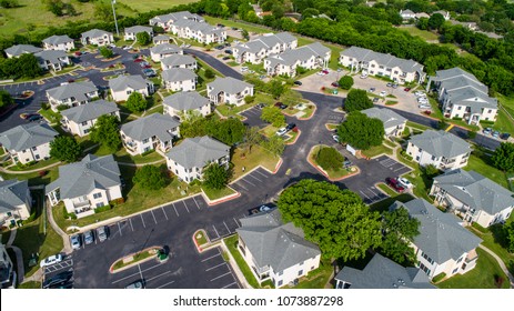 Apartment buildings and multistory townhomes a new development urban housing and Austin living - Aerial drone view - modern curved roads and large square two story townhomes