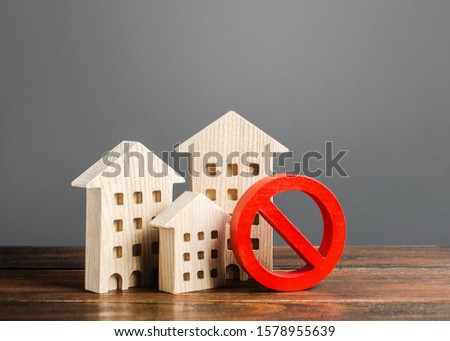 Apartment buildings and red prohibition symbol NO. Emergency and unsuitable for living building. Unavailable expensive housing. Lack of living space and the impossibility of building a new houses.