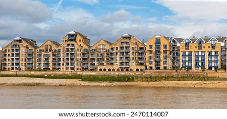 Apartment complex facing river Thames. Series of brown and blue houses at Wapping High Street, Wapping, London, United Kingdom.