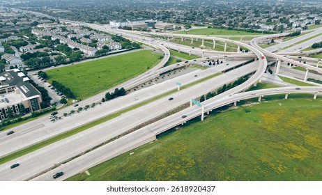 Apartment complex in master planned community near multilevel stack interchanges road junction, traffic movement, Dallas Parkway, Dallas North Tollway, President George Bush Turnpike, vacant land. USA