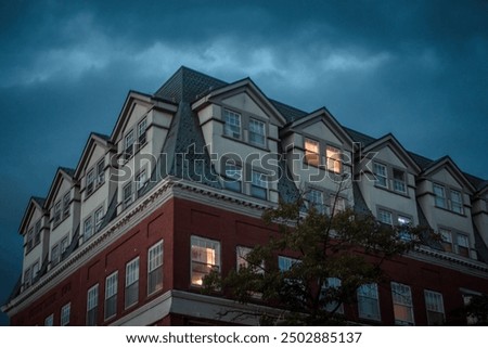 An apartment complex sits in the foreground of a dark and ominous sky right before a thunderstorm, seen in Salem, Massachusetts.