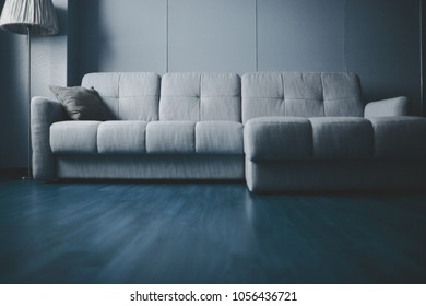 Apartment Interior With Couch And Floor Lamp Along The Wall.