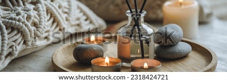 Apartment natural aroma diffusor ocean breeze fragrance. Banner. Burning candles on bamboo tray, cozy home atmosphere. Relaxation, detention zone in the living or bedroom. Stones, sea shells as decor