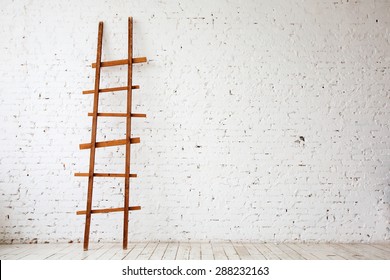 Apartment Renovation. Wooden Ladder near white Brick Wall in empty Room - Powered by Shutterstock