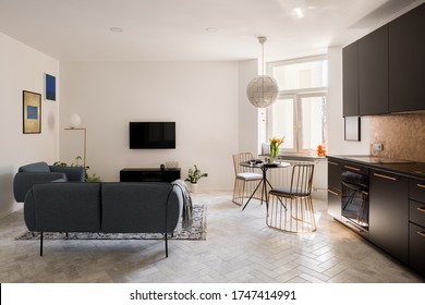 Apartment With Simple Living Room, Elegant Dining Table With Stylish Chairs And Modern Black Kitchen In One Room