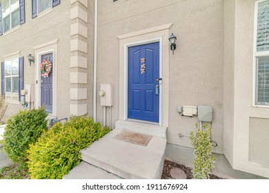 Apartment Unit With Vibrant Blue Front Door And Concrete Steps At The Entrance