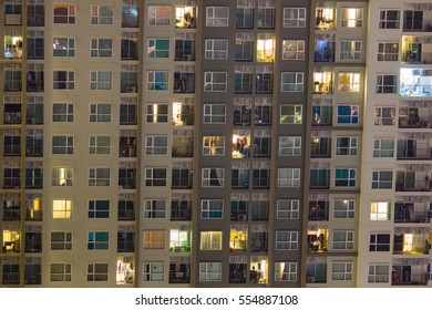 Apartment Windows At Night Showing A Vibrant Community Of Condos In A High-rise Building.  This Expensive Real Estate Is Hot In The Market Right Now And Only Expected To Grow, Following New Trends.