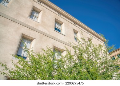 Apartments In Tucson Arizona With White Concrete Wall And Small Windows. Modern Multi-level Rsidential Building In Tucson Arizona Against Blue Sky On A Sunny Day.