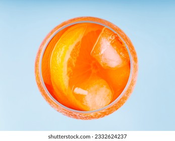 Aperol Spritz cocktail in glass on a blue background. Cocktail Aperol Spritz with orange slice and ice cubes. Top view