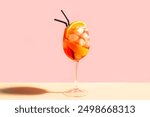 Aperol Spritz Cocktail in glass with orange slices on pink peach background, minimal trendy shot.  Alcohol Aperol Spritz Aperetivo.