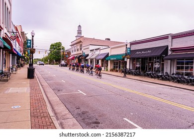 Apex, North Carolina USA-05 14 2022: A Group Of Cyclists Ride Through Downtown Apex.