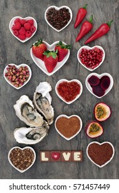 Aphrodisiac food with foods in heart shaped bowls and loose on marble background.