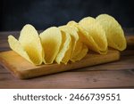 Apile of empty taco shells on a wooden work surface