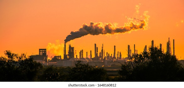 apocalyptic red skies above toxic smoke stacks emitting carbon pollution into the sky causing climate change  - Shutterstock ID 1648160812