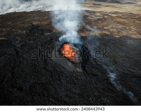 Apocalyptic surroundings of an erupted volcano, red hot lava boiling and pouring down the crater, volcanic gases and smoke spreading around the area, aerial side view.