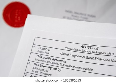 Apostille Certificate Document Corner And Red Notary Public Stamp On Official Document Seen On The Blurred Background.