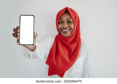 App Ad. Happy Black Islamic Woman Holding Smartphone With White Blank Screen In Hand, Gadget With Free Space For Website Or App Design, Mockup, Banner