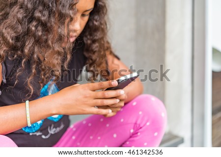 App game playing child with smartphone outside. 
Young girl walking on street with smartphone searching for application monsters in internet game, developed for devices