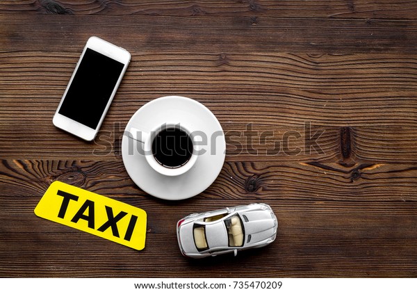 app for order a taxi\
online with car toy and mobile on wooden background top view space\
for text