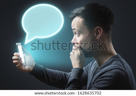 Appalled man getting a message on his smartphone