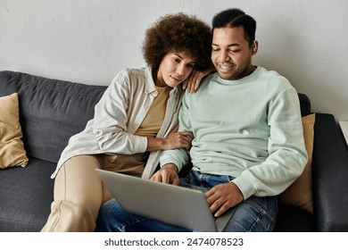 Appealing African American woman sitting near her husband with hearing aid and looking at laptop. - Powered by Shutterstock