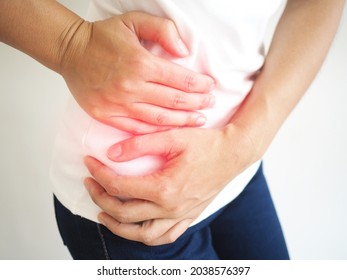 Appendicitis in asian women and she touches abdominal pain on the right side and position near the navel for health care concepts. closeup photo, blurred.