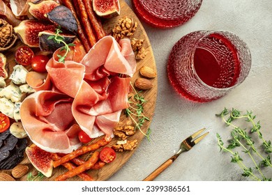 Appetizer from dry cured ham, prosciutto slices with figs and cheese. Dinner or aperitivo party concept. place for text, top view.