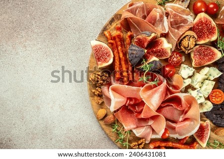Appetizer from dry cured ham, prosciutto slices with figs and cheese. Dinner or aperitivo party concept. place for text, top view.