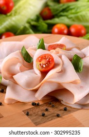 Appetizer Of Sliced Turkey Breast Rolled Up On The Cutting Board