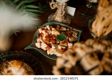 Appetizer or snack items presented on a distinctive decorative, leaf-shaped serving platter, set against a background suggesting a catering event.