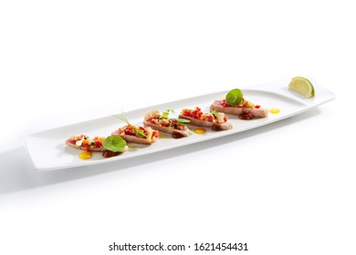 Appetizer With Tuna Tartar, Seasonal Vegetables And Greens On White Restaurant Plate Isolated. Macro Photo Of Delicious Healthy Red Fish Tatar Or Tar-tar Entree Closeup